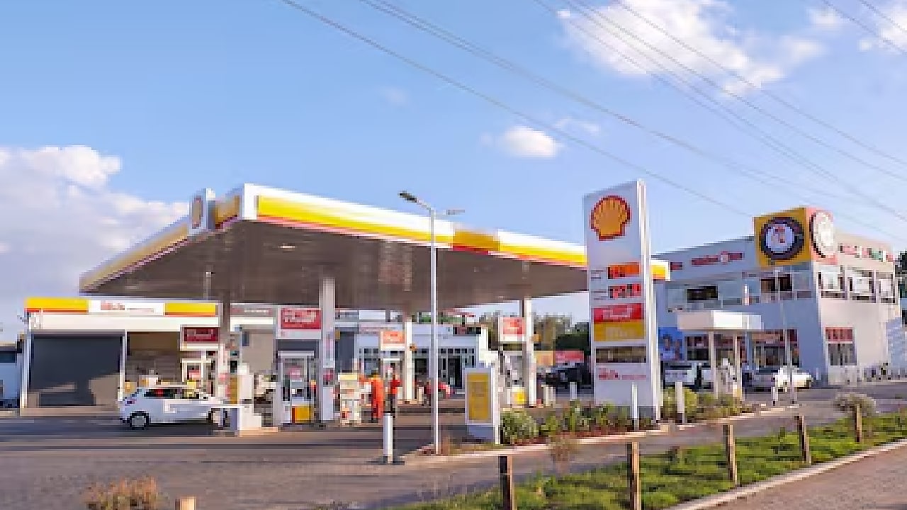 Shell service station in Kenya with multiple fuel pumps, vehicles refueling, and a convenience store in the background.