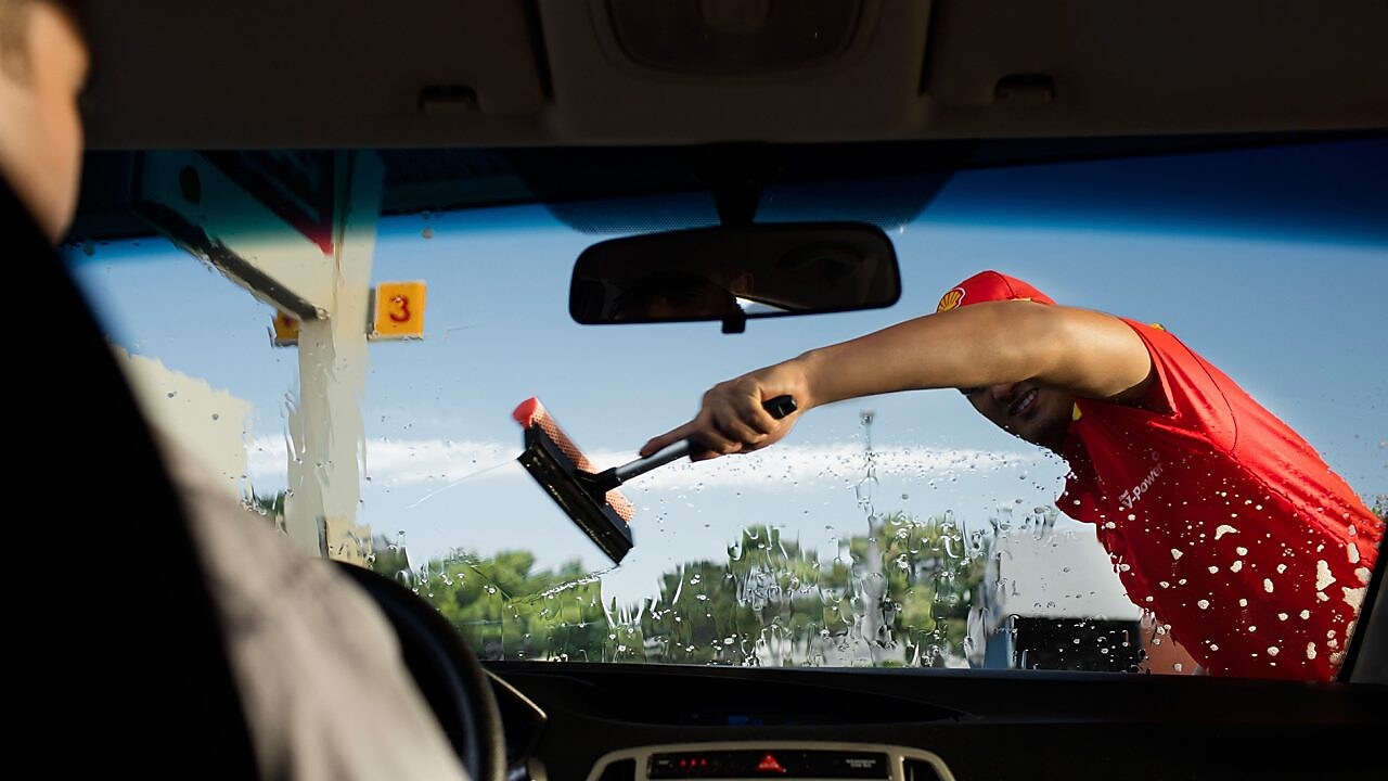 Shell assistant cleaning front screen of the car